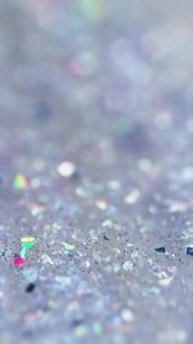 Dikey video. Sıvı sim dökülmüş. Parlak jel dokusu. Odaklanmamış holografik payet parçacıkları şeffaf ıslak parlatıcı sıvı akışı soyut sanat arkaplanı ve bokeh ışıkları.