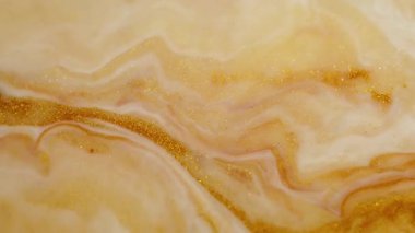 Parıltı karışımı. Boya damlası. Soyut arkaplana dökülen sarı altın sarısı beyaz parlak desenli jel emülsiyon dalgası.