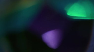 Işık efekti. Bulanık parlak yuvarlak. Odaklanmamış mor yeşil kıvılcım kıvılcımlı çerçeve ışığı soyut bokeh koyu siyah sanat arka planında yüzüyor..