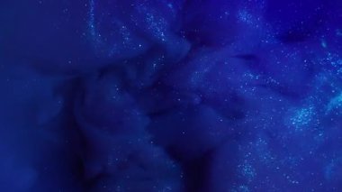 Parlayan toz. Boya patlaması. Sıvı arka planda parlak dumanlı mavi dalga sızıntısı. Sanat sıvısı akışı soyut bulanık doku.