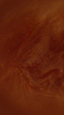 Dikey video. Mürekkep suyu. Bulanık sim tozu. Kırmızı kahverengi parçacık dokusu duman lekesi koyu siyah soyut sanat arka planına boya sıvısı sıçrıyor.