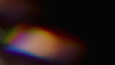 Parıltı. Bulanık sanat ışığı. Odaklanmamış mavi yeşil parıltı gökkuşağı tayfı koyu siyah arkaplanda parıldıyor.