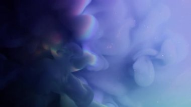 Bulut boyası. Duman patlaması. Mavi mor mor, yeşil, sisli, neon akış fantazisi parıldayan sıvıya yayılıyor. Gökkuşağı ışığının soyut arkaplanını ışınla.