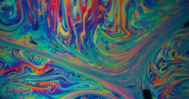 Damla dokusu. Benzin sızıntısı. Soyut sanat arka planında yüzen mavi boya baloncukları akarken odaksız yeşil mor renk..