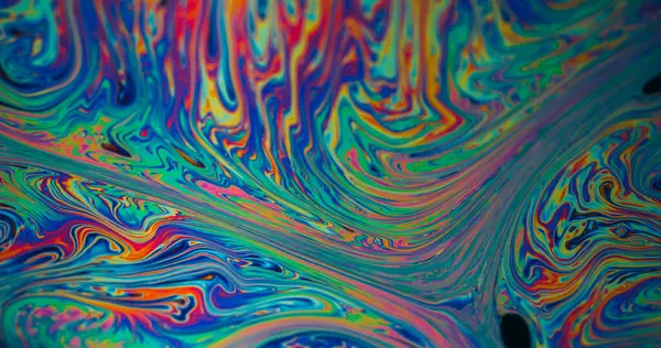 Damla dokusu. Benzin sızıntısı. Soyut sanat arka planında yüzen mavi boya baloncukları akarken odaksız yeşil mor renk..