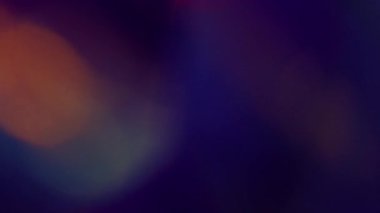 Işıl ışıl. Bulanık ışın. Odaksız mavi turuncu çok renkli gökkuşağı kıvılcımlı mercek koyu siyah arka planda yüzüyor..