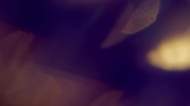 Işın aydınlatıldı. Bulanık yanardöner sızıntı. Soyut koyu siyah arkaplanda sönük mavi çok renkli mercek parlaklığı.