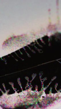 Dikey video. Çatlak göster. Grunge dereleri. Dalgalı siyah sıvıyı ışık tanecikli bozulma yayın arızası ekranına yayıyor. Kırık piksel dokusunun gökkuşağı parıltısı.