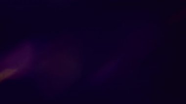 Işık efekti. Bulanık işaret fişeği. Odaklanmamış mavi mor renkli lens soyut koyu siyah arkaplan üzerinde parıltı deseni.