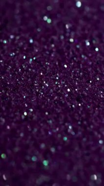 Vertical video. Defocused shine. Purple glitter. Flare shimmering festive surface with metallic dust. Violet overflows on precious fine lilac powder.