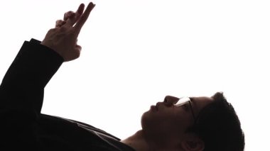 Dikey video. İş sohbeti. Akıllı siluet. Dijital pazarlama. Beyaz boş arkaplanda izole edilmiş cep telefonu kullanan adamın karanlık profili.