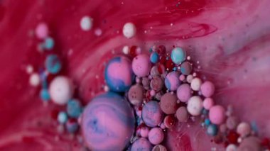 Dikey video. Boya karışımı. Yağ kabarcıkları. Renkli akrilik damlaları karıştıran parlak mermer bulanıklığı. Dalga suyu kırmızı pembe mavi sızıntı soyut arkaplan.