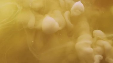 Mürekkep dalgası. Toz dokusu. Suyun içindeki çözünmüş sarı boya ruhani bulut sıvısı soyut sanat eserlerinin yaratıcı arka planına yayılıyor..