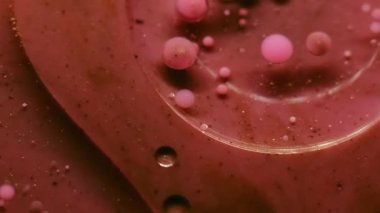 Mürekkep sıvısı. Jel köpükleri. Soyut sanat eserlerinin arka planına dökülen su sıvısındaki pembemsi pembe boya yuvarlak deseni..