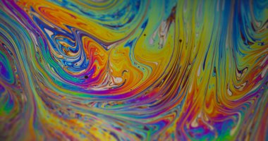 Damlacık yağı. Renk karışımı. Odaklanamayan sarı mor mavi mürekkep su dokusu akan yeşil yuvarlak lekeler soyut sanat arka planına dökülüyor.