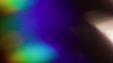 Parlak kiriş. Bulanık renk soyutlaması. Odaklanamayan mavi yeşil gökkuşağı spektrumu açık mercek koyu siyah arkaplanda yanıp sönüyor.