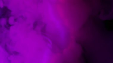 Boya buharı. Pigment akışı. Mor pembe sis akıntısı siyah parlak yüzeyde akıyor. Açık lens neon renk karışımı soyut arkaplan bulanıklığı.