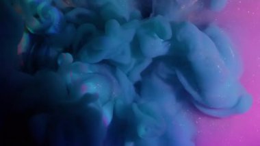 Duman girdabı. Parıldayan parçacıklar. Çok renkli sıvı yüzeyde mavi sisli boya patlaması. Gizemli su karışımı soyut arkaplan.
