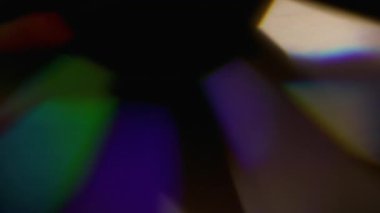 Parlak ışık. Bulanık ışıltı. Soyut koyu siyah arkaplanda yüzen mavi kırmızı renkli yuvarlak mercek parlaklığı.