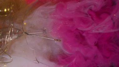 Dikey video. Parlak duman. Renkli puf. Patlayan pembe bulut boyası beyaz altın parıltılı sanat eseri, sıvı peçe arka plan sıvıları kırık cam çelenk ışıkları..