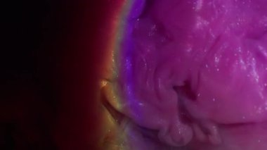 Mürekkep girdabı. Işıldayan akış. Pembe, mor, nemli yüzey kemer bulanıklığı ve gökkuşağı parlaklığı karışımı. Soyut mercek boyası su siyah arkaplan.