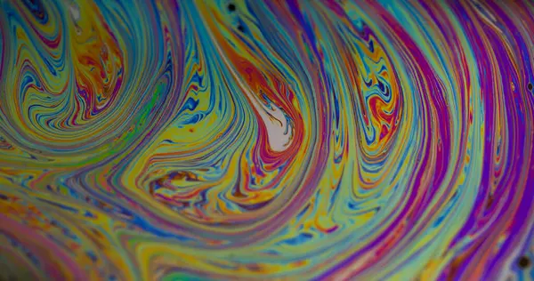 Boya karışımı. Su yakıtı. Odaklanamayan sarı mor renkli mürekkep akrilik arka planda mavi lekeler sızıyor..