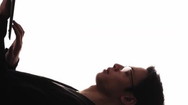 Dikey video. Çalışan siluet. Uzaktan kumanda. Dijital pazarlama. Beyaz boş arkaplanda izole edilmiş dizüstü bilgisayar kullanan kendine güvenen bir iş adamının karanlık profili..