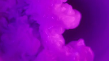 Işıldayan akış. Mor duman. Parlak renkli boya pigmenti suda çözünüyor. Odaklanmamış neon bulutu patlaması soyut arkaplan.