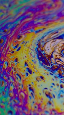 Dikey video. Asit sıvısı. Kabarcık boyası. Odaklanamayan mor yeşil gökkuşağı eğrisi akrilik kaygan koyu siyah bulanık ışık soyut sanat arkaplanı.