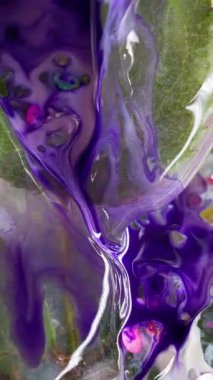 Dikey video. Violet taştı. Boya buz döker. Mor akarsu dumanlı dalgalanmalar donmuş yapraklar arasında. Sıvı mermer eflatun parıltılı karışım çözünmüş arkaplan.