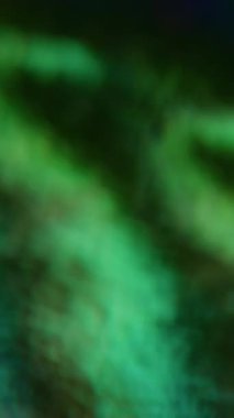 Dikey video. Retro hologram. Bulanık ışık sızıntısı. Odaklanamayan sızıntı, çok renkli yeşil ışınlar, gökkuşağı titreşimleri, soyut sanat efekti arka planında ışık gradyan lensler..