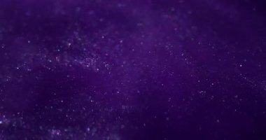 Parıltılı boya. Toz sıvısı. Mor parçacıklar suya parlak pigmentler döküyorlar. Parlak soyut bulanık bulut patlaması arka planda parlıyor.