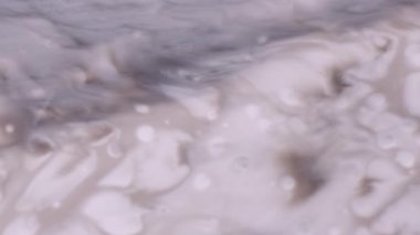 Mürekkep lekesi. Boya sıçraması. Beyaz sıvı top damlası grunge akrilik dokusuna düşer. Su sıçratma gri pigmenti çözünmüş soyut arkaplan.