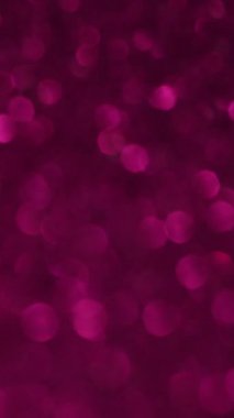 Dikey video. Bokeh daireleri. Renkli güneş ışığı. Aydınlatılmış yuvarlak noktalı değişken dağılım. Havalı mistik parıltısıyla şenlikli bir arka plan..