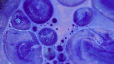 Ink blob. Defocused wet drop. Blinking gleaming foam paint sparkling light blue color oil liquid moving on abstract modern background.