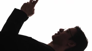 Dikey video. Birkaç siluet. Romantik sohbet. Mesafe ilişkisi. Telefon mesajları kullanan mutlu bir adamın, beyazlar içinde izole edilmiş sevgilisine canlı yayında öpücük yollamasının karanlık profili..