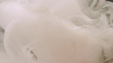 Sıvı sis. Soyut mürekkep. Odaklanamayan beyaz renkli duman ruhani bulutlar kimyasal suyu karıştırıyor. Yaratıcı siyah arka planda uçuyorlar..