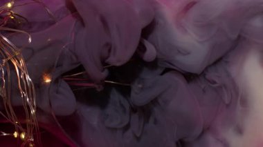 Dikey video. Mürekkep fırıl fırıl dönüyor. Grunge dumanı. Sihir, pembe gri sisli sıvı boya küçük parçacıklar arka plan deseni ve kırık cam ışıklı ekipman karışımı..