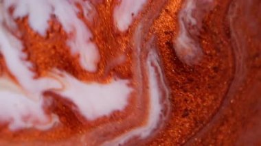 Parlayan kum. Boya yayılmış. Turuncu kırmızı bakır metal parçacıkları akrilik akrilik sıvı mermer yüzey soyut bulanık arkaplanı karıştırıyor.
