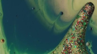 Boya akışı. Sanat sıvısı. Yeşil sarı sıvı sızıntı... yağ lekesi... pudra yüzeyi. Renk parçacıklarını soyut bulanık arkaplanla karıştır.