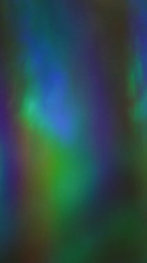 Dikey video. Bulanık gökkuşağı hologramı. Folyo dalgalı doku. Odaklanamayan sızıntı, çok renkli yeşil ışınlar, titreşimli ışınlar, sanat arkaplanındaki ışık yansıması..