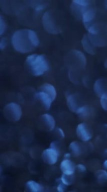 Dikey video. Odaklanmış spektrum. Gökkuşağı ışıkları. Aydınlatılmış renkli noktalarla değişken dağılım. Havalı mistik parıltısıyla şenlikli bir arka plan..