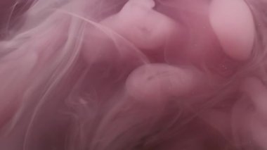 Duman bombası. Buhar bulutu. Soyut koyu siyah arkaplan üzerinde dalgalanan su patlaması akışındaki sönük mor renkli sıçrama mürekkebi.