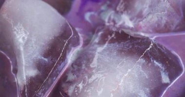 Parlak sıvı. Parlak. Odaklanmamış mor beyaz renkli buzlu su. Buz dokusu. Islak damlacıklar soyut soğuk sanat arka planına dökülüyor..