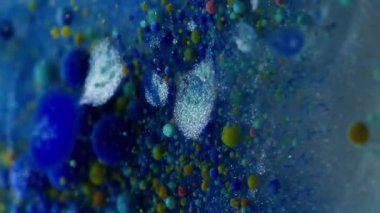 Dikey video. Yağ pigmenti düşüyor. Mürekkep patladı. Baloncuklu jel boya parlak suda çözünür. Yaratıcı sıvı karışımı soyut arka plan köpük dokusu.