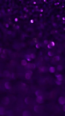 Dikey video. Bokeh parıldıyor. Hipnotik ışıltı. Koyu arkaplanda parlayan farklı kumların küçük ışık noktaları. Değişen parıltı perisi ışıltıyı dağıttı.