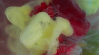 Dikey video. Sanat buharı. Karanfil dumanı. Çiçek doğasında sarı beyaz sisli boya karışımı kırmızı taç yaprağı soyut arkaplan su pigmenti..