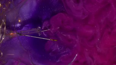 Dikey video. Mürekkep simleri. Dumanlı akış. Işıldayan hipnotik pembe dalgalı dalgalar küçük parlak parçacıkların içinde karışıyor. Bulutlu renk akış arkaplanı.