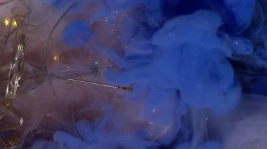 Dikey video. Mürekkep akışı. Boya çözülüyor. Soyut arkaplan ampulü üzerinde parlak renk akışları çakışır. Süt gibi köpüklü suda canlı mavi bulut.