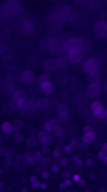 Dikey video. Bokeh zayıflıyor. Renkli titreşimler. Küçük ışık parçacıkları renk değiştirir. Psikedelik bulanık atmosfer değişken gökkuşağı toz kırılması.